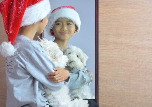 男孩抱着小狗照镜子
