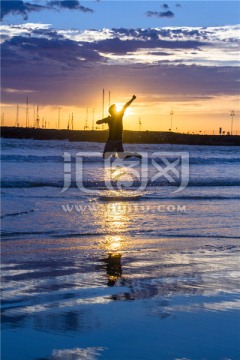 阿波罗港日出海滩上跳跃的少年