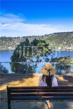 坐在长椅子上观赏南澳蓝湖的女孩