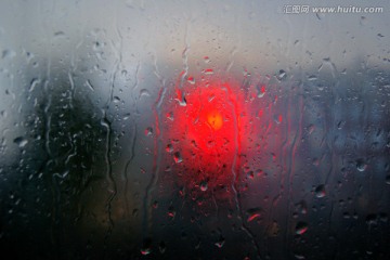 透过玻璃看雨中的红绿灯
