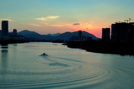 天空夕阳江中船只