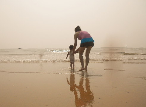 父母和小孩的海滩背影