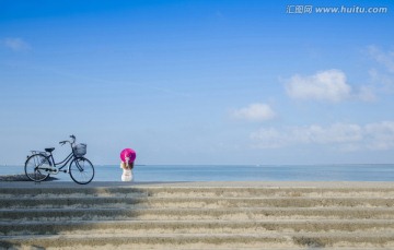 游客骑自行车海边度假版高清大图