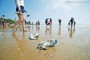 沙滩上的凉鞋和游客