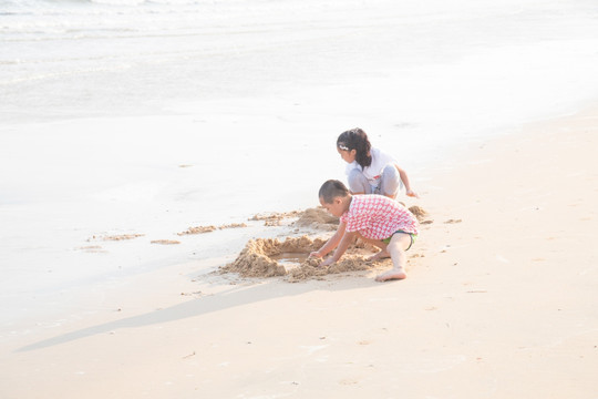 逆光下沙滩上玩耍的儿童背影