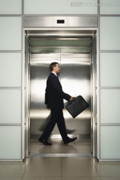 电梯里带着公文包的商务人士
