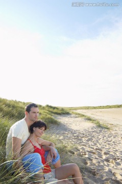 夫妇坐在沙滩上看海