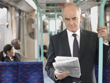 商人在火车上读报纸 