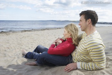 坐在沙滩上拥抱的情侣