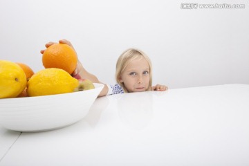 小女孩拿着橘子