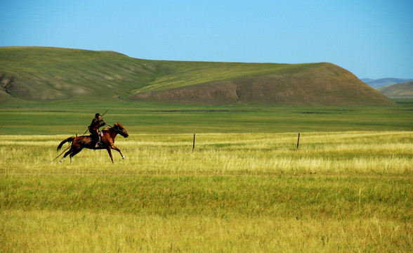 草原上骑马飞奔的蒙古族