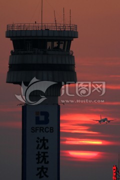 夕阳中的塔台和飞机降落