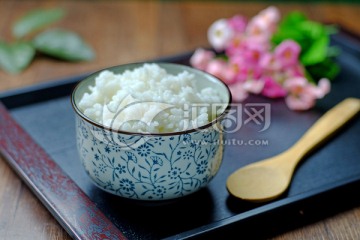 青花碗中的米饭和木勺放在托盘中