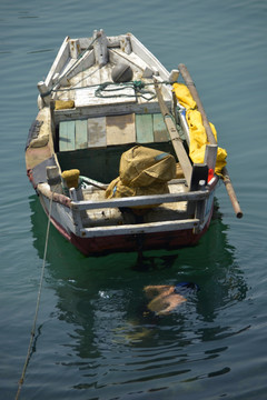 小渔船边潜水捕鱼的渔民