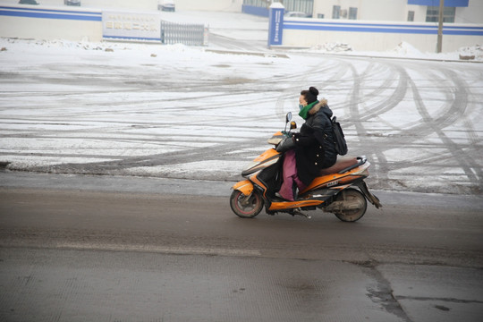 下雪天骑电动摩托的人