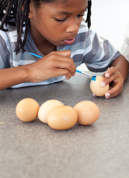 可爱的黑人小男孩画鸡蛋