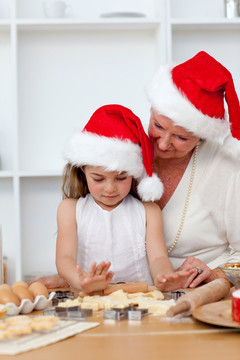 祖母和小女孩烤圣诞蛋糕