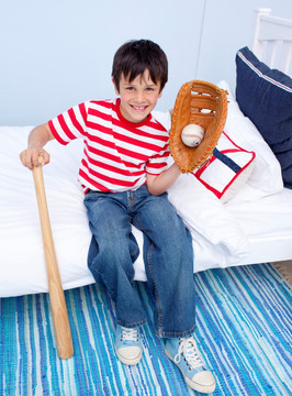 小男孩在卧室里打棒球
