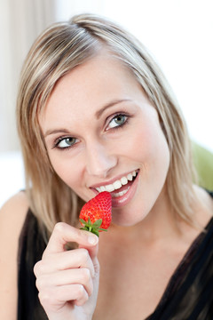 微笑的女人吃一个草莓