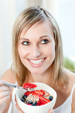 微笑的女人在吃水果麦片