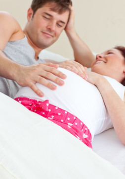 躺在床上的孕妇和她的丈夫