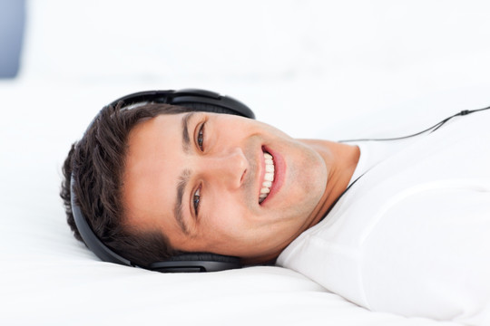 男子躺在床上听音乐