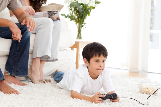 在地板上玩电子游戏的小男孩