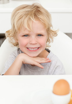 在厨房吃鸡蛋的小男孩