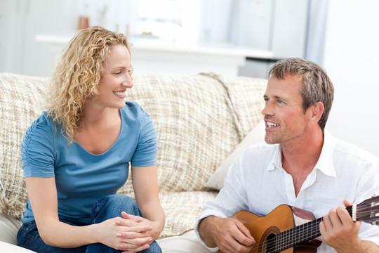 浪漫男人在家里为妻子弹吉他