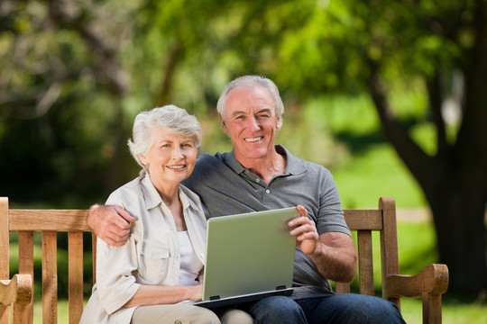 老年夫妇看他们的笔记本电脑