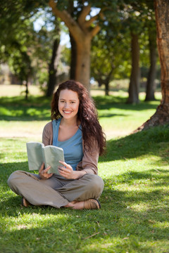 坐在公园草地上读书的女人