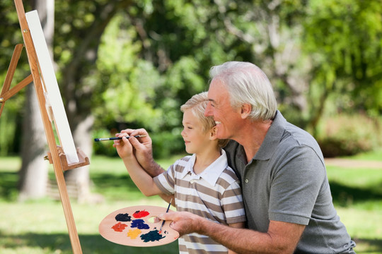祖父和他的孙子在花园里画画