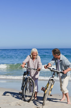 在海边骑自行车的老年夫妇