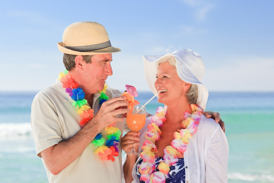 沙滩上喝饮料的老夫妇