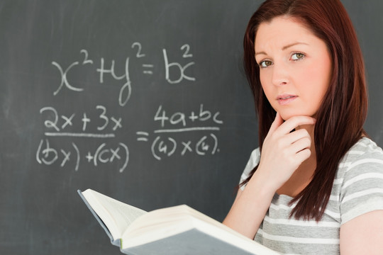 在黑板上解方程的女学生