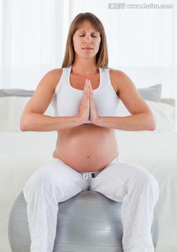 孕妇坐在健身球上做瑜伽