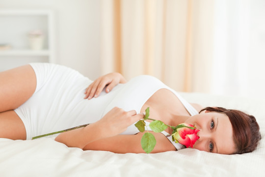 躺在床上闻着玫瑰花香的女人