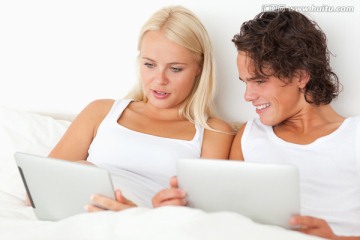 年轻夫妻在床上看书
