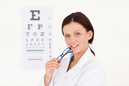 戴眼镜的女医生和视力测试表