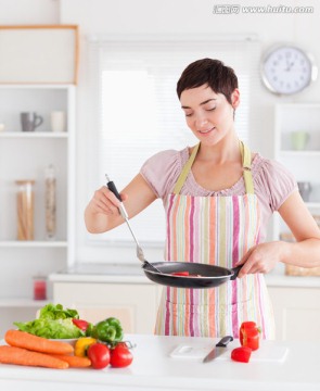 微笑的女人在厨房里做饭