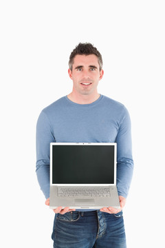 男人抱着一台笔记本电脑