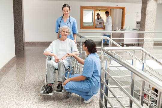 两名护士照顾坐在轮椅上的老妇人
