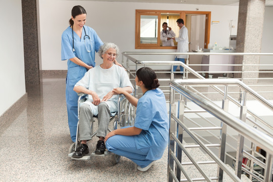 轮椅上的老人与护士在走廊上交谈