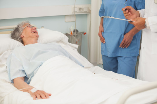 老年女性患者微笑看着护士和医生