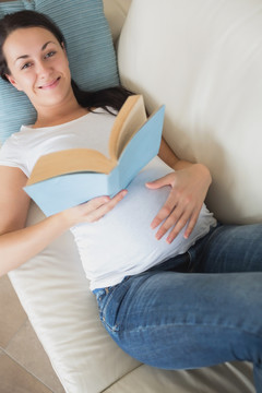 孕妇躺在沙发上看书