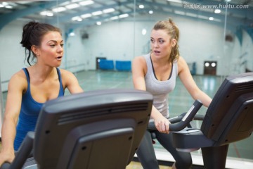 两个在健身房锻炼自行车的女人