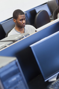 坐在机房电脑前的男学生
