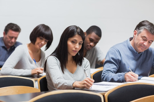 在大学演讲中做笔记的学生