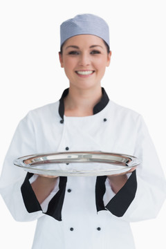 女厨师拿着一个空的银托盘
