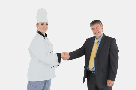快乐的商人和女厨师握手